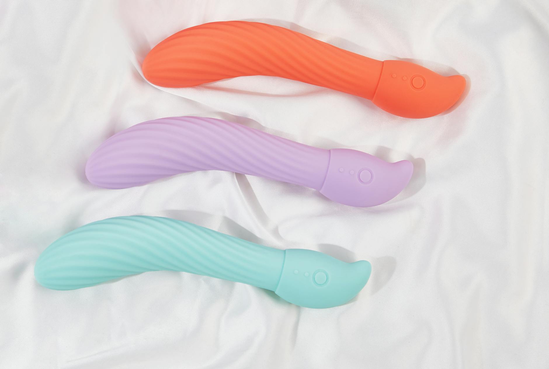 Three smooth lemon clitoral vibrators arranged on soft white fabric, showing their sleek design