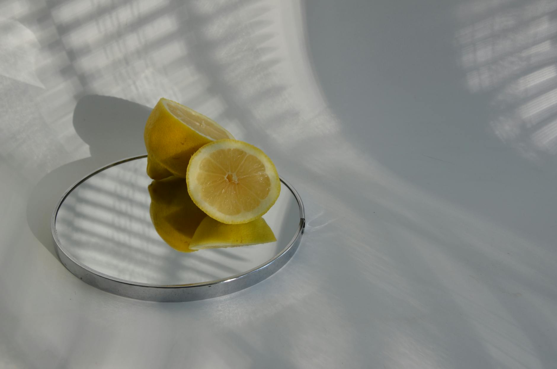 Sliced lemons arranged on a mirrored surface, symbolizing the cyclical phases of sensation and pleasure.