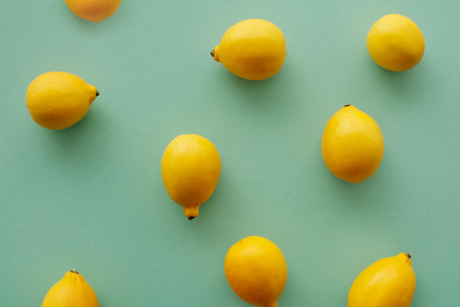 Bright yellow lemons arranged on a pastel green background, representing fresh starts and gentle reintroduction to pleasure