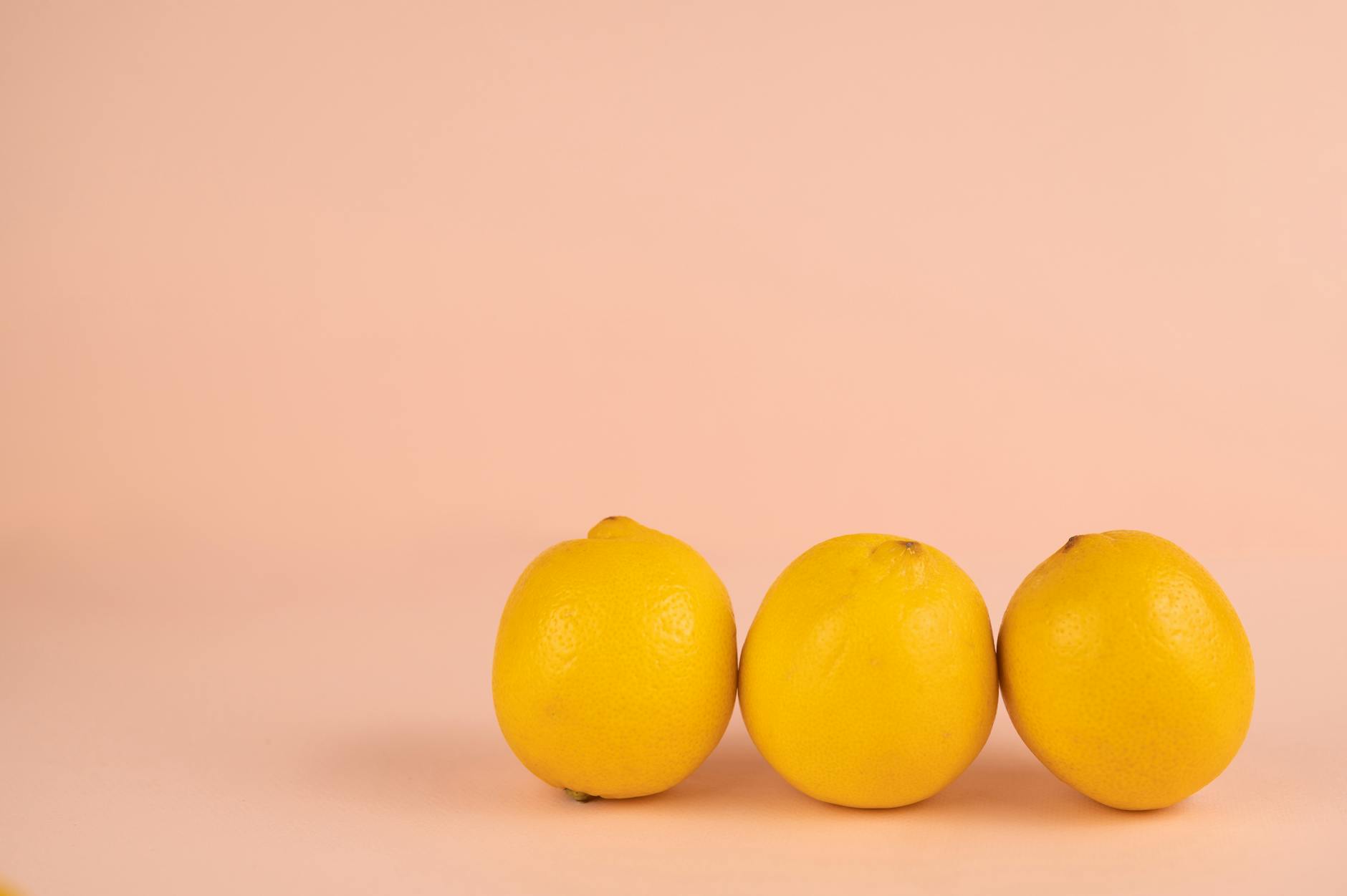 Bright ripe lemons arranged on a pastel background representing external pleasure focus