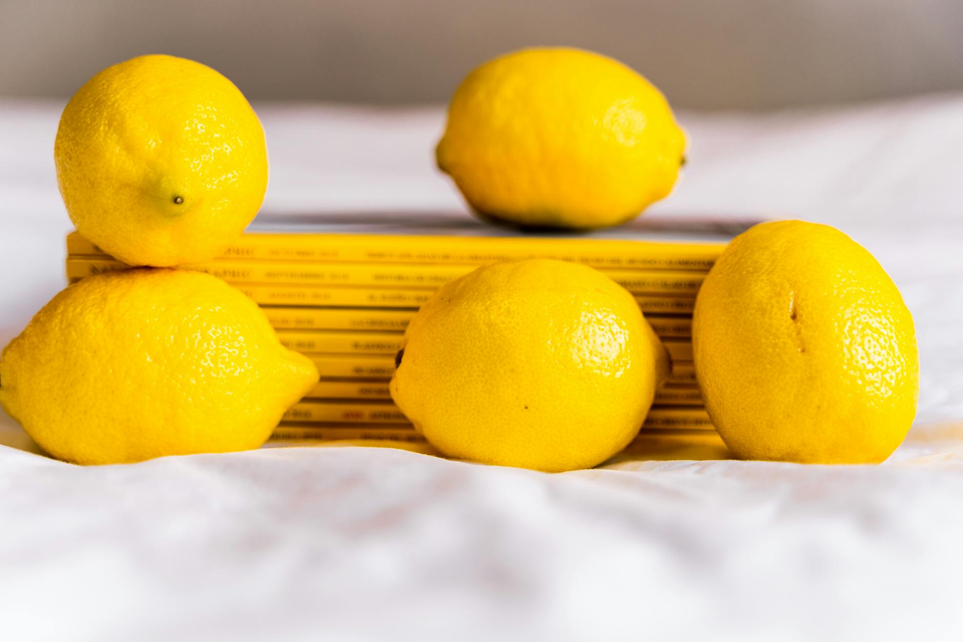Bright yellow lemons arranged on a soft green background